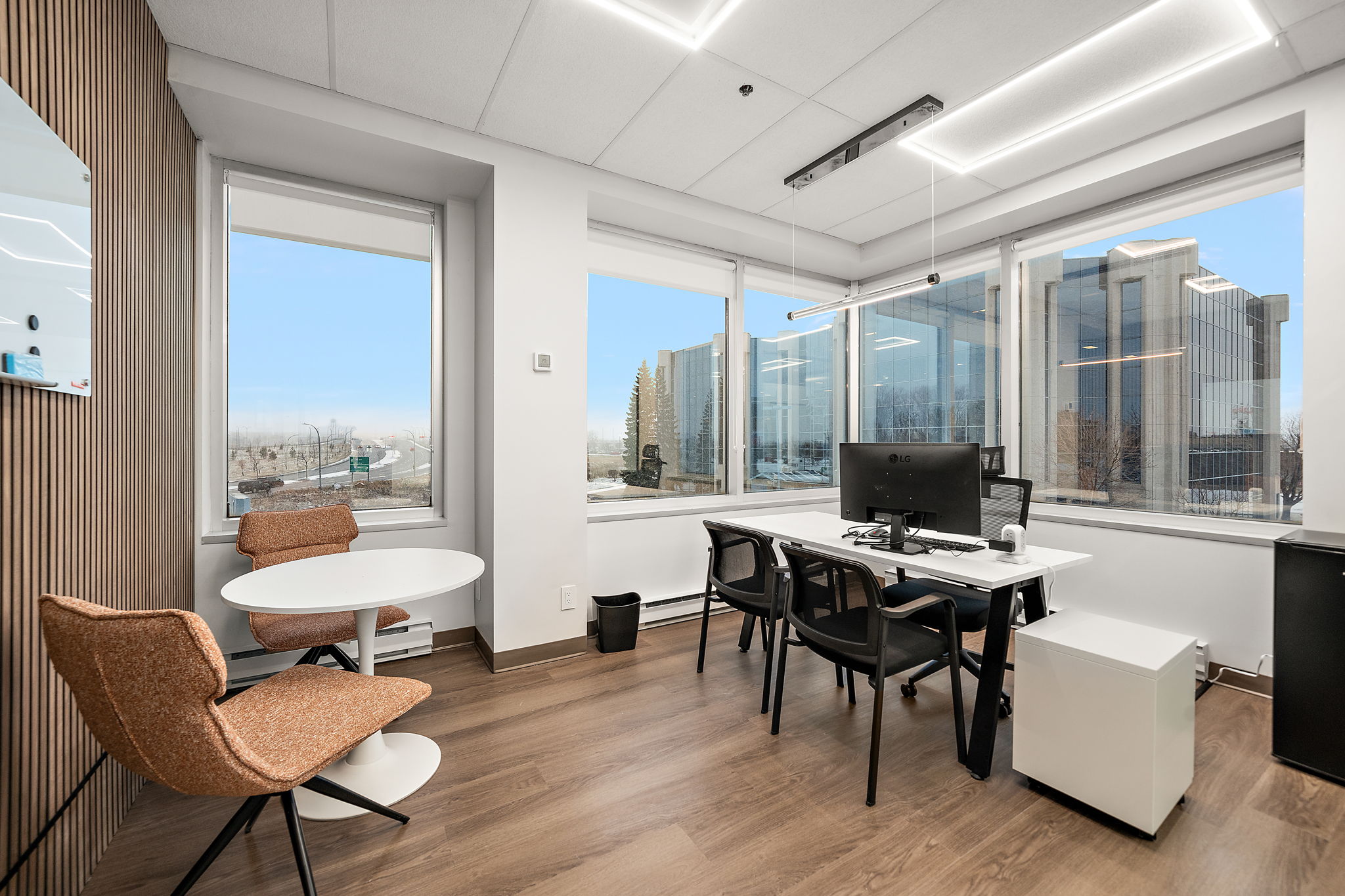 Bright furnished Swivl private office with a spacious desk, monitor, magnetic whiteboard, storage, mini fridge and conference area